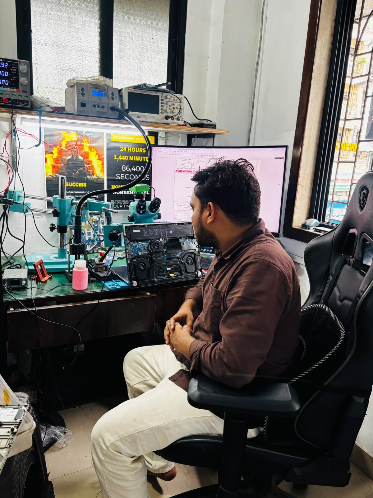 Instructor diagnosing laptop at workstation